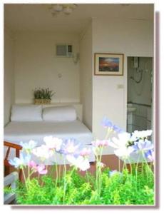 a bed in a room with flowers in the foreground at Jiou Fen Seaside HomeStay in Jiufen