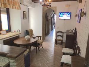 a living room with a table and a tv on the wall at Casa Rural La Villa in Castro del Río