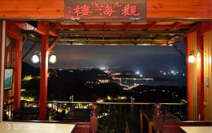a restaurant with a view of a city at night at Jiou Fen Seaside HomeStay in Jiufen