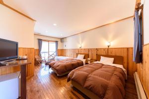 a hotel room with two beds and a flat screen tv at Ginga no Yado Kinoko2seigo in Shimo-tashiri
