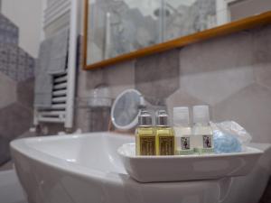 un lavandino in bagno con tre bottiglie di oli essenziali di Relais Palazzo Duomo B&B a Nola