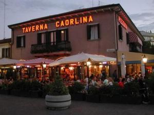 a group of people sitting outside of a restaurant at Alloggi Taverna Caorlina in Caorle