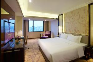 a hotel room with a large white bed and a window at Xiamen Airlines Lakeside Hotel in Xiamen