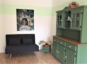 - un salon avec un meuble vert et un canapé dans l'établissement Ferienwohnung Drößler, à Mühlhausen