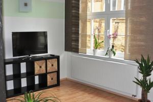 a living room with a television and a window at Ferienwohnung Drößler in Mühlhausen