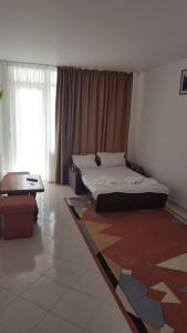 a bedroom with a bed and a table in it at Hotel Forum in Costinesti +23 photos