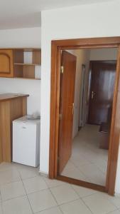 una puerta abierta a una cocina con nevera en Hotel Forum, en Costinesti