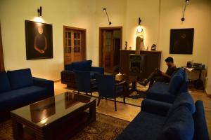 a man sitting in a living room playing a video game at Deodar Homestay in Almora