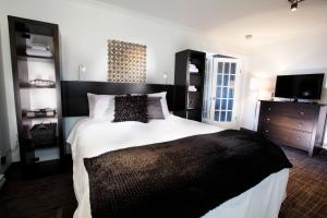 a bedroom with a large bed with a black headboard at Riotel Perce in Perce