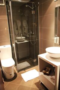 a bathroom with a shower and a toilet and a sink at Arber Hotel in Tirana
