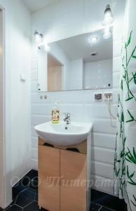 y baño con lavabo blanco y espejo. en PiterStay Nevsky 32, en San Petersburgo
