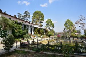 a house with a pond in the yard at Deodar Homestay in Almora