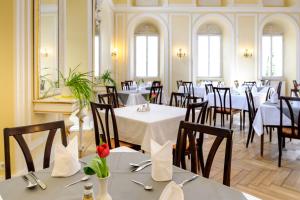 a restaurant with tables and chairs in a room at Hotel Kurhaus Bad Bocklet in Bad Bocklet