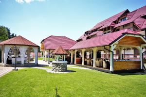eine Reihe von Häusern mit roten Dächern auf einem Rasen in der Unterkunft Q Resort and Spa in Săcele