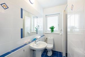 Un baño blanco con inodoro y lavabo. en Villa Elefant, en Międzyzdroje 30 fotos más