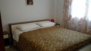 a bed with two pillows and a window in a room at Nettuno 53 in Grado