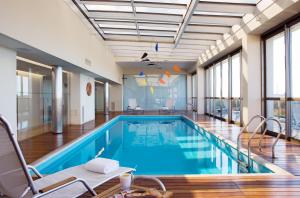 a swimming pool with chairs and a table in a building at Hotel Madero Buenos Aires, WorldHotels Elite in Buenos Aires