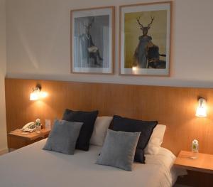 a bedroom with a bed with two tables and two pictures on the wall at Logis des Sittelles in Montfort-le-Gesnois