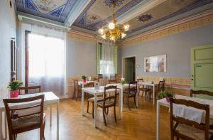 a dining room with tables and chairs and a chandelier at Villa Sant’Andrea in Siena