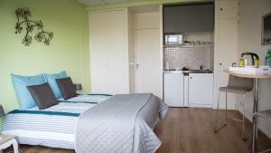 a small bedroom with a bed and a kitchen at Studios étape du Lac in Bourbon-Lancy