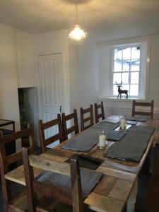 a dining room with a wooden table and chairs at Leirsinn Mhor in Killin