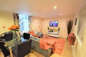 a living room with a couch and a tv at Meridian Way - 3 Bed Apartment - Sleeps 7 in Bristol