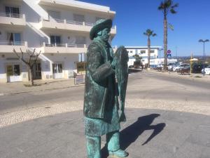 una estatua de un hombre parado en una calle en casanova, en Fuseta