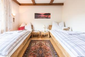 2 Betten in einem Zimmer mit einem Teppich in der Unterkunft Apartment Anny in Bruck an der Großglocknerstraße
