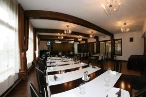 a dining room with white tables and black chairs at Chalet Minut in Vatra Dornei