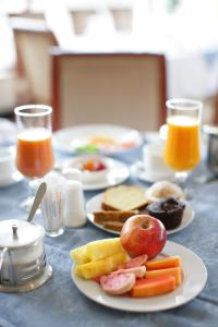 a table with plates of breakfast foods and orange juice at Wassamar Hotel in Addis Ababa