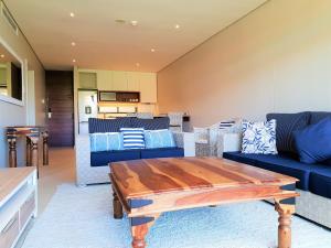 Zimbali Suite 311 في باليتو: غرفة معيشة مع أرائك زرقاء وطاولة
