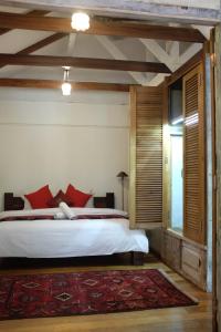 1 dormitorio con 1 cama grande con almohadas rojas en Panji Panji Tropical Wooden Home, en Pantai Cenang