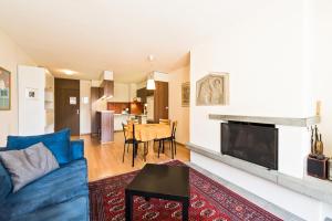 a living room with a blue couch and a fireplace at Appartementhaus-Quadern in Valens +27 photos