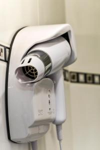 a hair dryer hanging on a wall in a bathroom at Hôtel Paris Nord in Paris