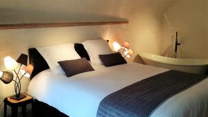 a bedroom with a large white bed with two pillows at MY SWEET HOMES - STUDIO "LE CAVEAU" in Colmar