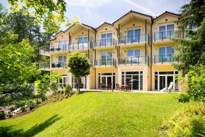 an exterior view of a large yellow building with a yard at Hotel Villa Marburg im Park in Heigenbrücken