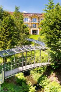 a bridge over a river with a building in the background at Hotel Villa Marburg im Park in Heigenbrücken
