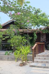 a house with some plants in front of it at Panji Panji Tropical Wooden Home in Pantai Cenang
