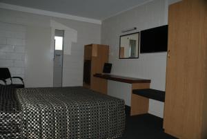 BlackwaterにあるBlack Diamond Motelのベッドとテレビが備わるホテルルームです。