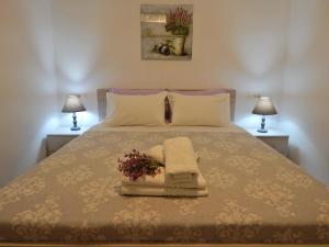 a bed with a pile of towels and flowers on it at Psaromoura Apartment in Agia Pelagia