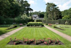 einen Garten mit Rosen und Blumen im Gras in der Unterkunft Relais & Chateaux Hotel Landgoed Het Roode Koper in Ermelo