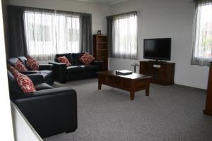 a living room with two couches and a tv at Harbour View Motel in Timaru