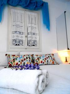 a bedroom with a bed and a window with blue curtains at Angeliki Pension in Katapola