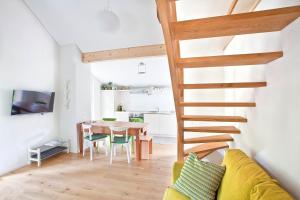 uma sala de estar com uma escada de madeira e uma mesa em MyVerzasca Resort Casa Rossa em Brione