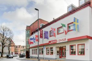 un edificio con banderas a su lado en una calle en INA Hotel Consul en Kiel