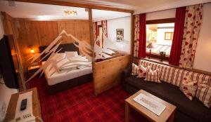 マイヤーホーフェンにあるHotel Garni Larcherhofのベッド1台とソファが備わる小さな客室です。