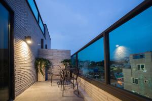 a balcony with two chairs and a table at Brown-Dot Hotel Choeup in Busan