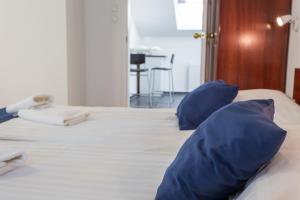 Una cama con dos almohadas azules encima. en Classic Hotel en Budapest