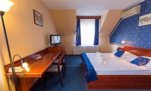 Cette chambre comprend un lit et un bureau. dans l'établissement Classic Hotel, à Budapest
