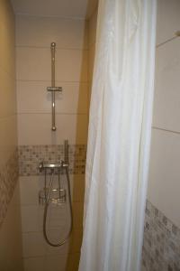 W łazience znajduje się prysznic z białą zasłoną prysznicową. w obiekcie Skruzdynės Apartamentai w mieście Nida +26 zdjęć